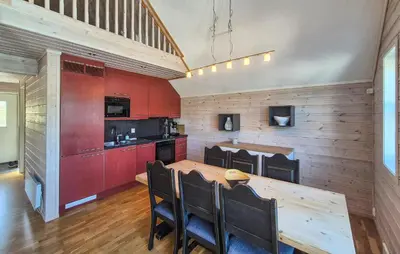 a kitchen with a wooden table and red cabinets at Nice Apartment In Auklandshamn in Vestvik