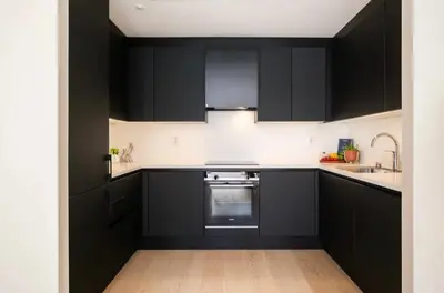 a kitchen with black cabinets and a sink at Wow in Bergen
