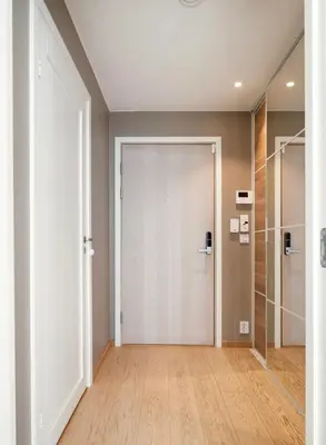 an empty hallway with a white door and wooden floors at Wow in Bergen