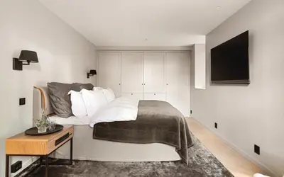 a bedroom with a bed and a television on a wall at Exclusive Villa - Scandinavian Luxury At Its Best in Bergen