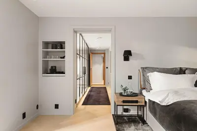 a bedroom with a bed and a table next to a door at Exclusive Villa - Scandinavian Luxury At Its Best in Bergen