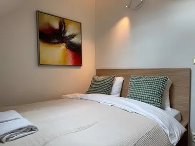 a bedroom with a bed with a painting on the wall at Heimby Homes - Four Bedroom Family Penthouse in Bergen
