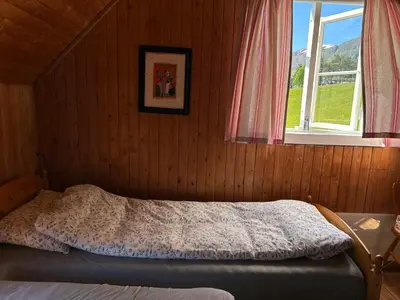 a bedroom with a bed in a room with a window at Historic Farmhouse In Scenic Isfjorden in Isfjorden