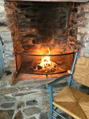 a fire place with a chair and a fireplace at Historic Farmhouse In Scenic Isfjorden in Isfjorden