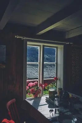 a dining room table with a view of a window at Historic Farmhouse In Scenic Isfjorden in Isfjorden