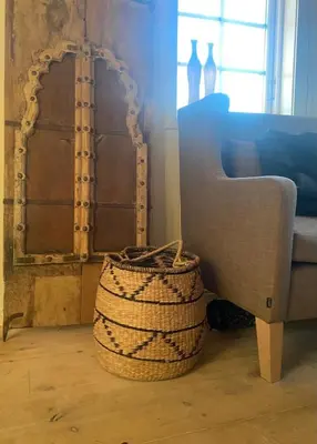 a room with a chair and a basket and a mirror at Ingeborgstova in Lii