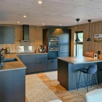 a kitchen with blue cabinets and a large island at Mountain Cabin With Sauna In Sunnmørsalpane in Brunstad