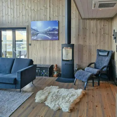 a living room with a couch and a fireplace at Mountain Cabin With Sauna In Sunnmørsalpane in Brunstad