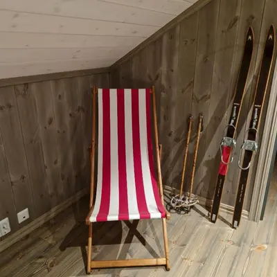 a red and white striped chair next to some skis at Mountain Cabin With Sauna In Sunnmørsalpane in Brunstad