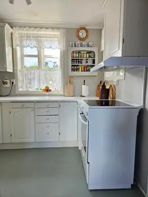 a kitchen with white cabinets and a stove top oven at Sentralt i Sogndal terrasse med fjordutsikt in Sogndal