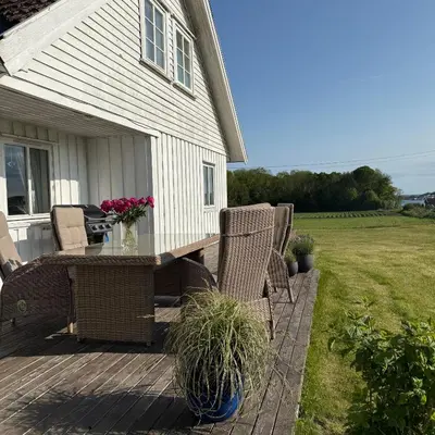 a patio with chairs and a table with flowers on it at 047 Farmhouse - Nevlunghavn in Lii