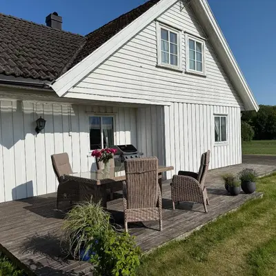 a wooden deck with a table and chairs in front of a house at 047 Farmhouse - Nevlunghavn in Lii
