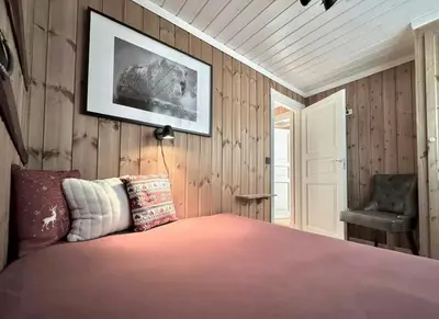 a bedroom with a bed and a chair at Modern Family Cabin By The Ski Lift in Flå