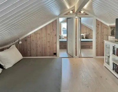 a attic bedroom with a bed and a room with at Modern Family Cabin By The Ski Lift in Flå