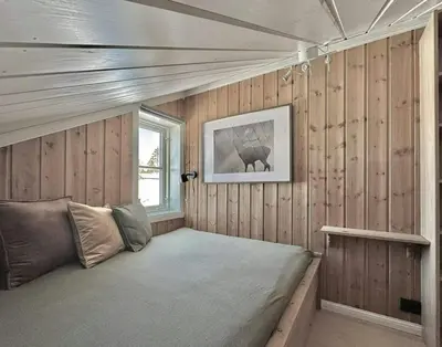 a bedroom with a bed in a wooden wall at Modern Family Cabin By The Ski Lift in Flå