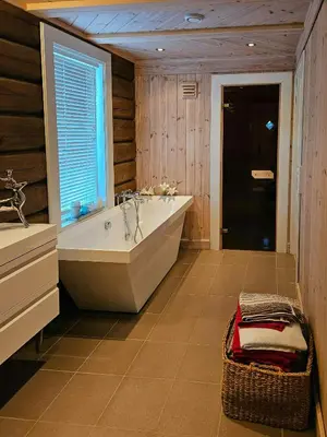 a large bathroom with a tub and a window at Timber Cabin With Mountain Views In Synnfjellet in Skartlia