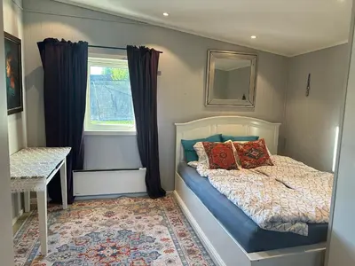 a small bedroom with a bed and a window at Scandinavian Style Ridabu Hamar in Hamar
