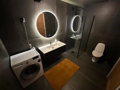a bathroom with a sink and a washing machine at Leilighet nært sentrum in Stryn