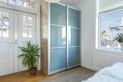 a glass door in a hallway with a potted plant at Stor 3-roms leilighet med utsikt in Trondheim