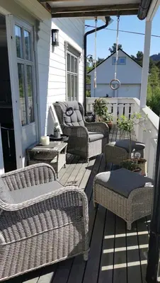 a porch with wicker furniture on a house at Summer villa with heated pool 50 min from Bergen