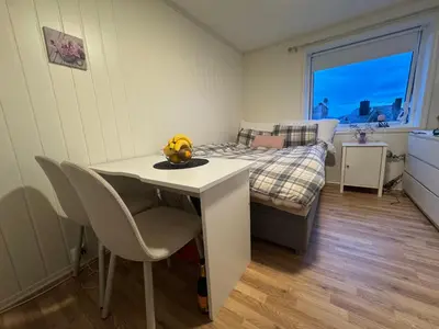a bedroom with a bed and a table and chairs at Alesund center room with double bed in Ålesund