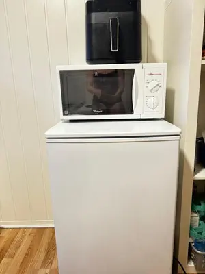 a microwave sitting on top of a white refrigerator at Alesund center room with double bed in Ålesund