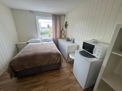 a small bedroom with a bed and a television at Alesund center room with double bed in Ålesund