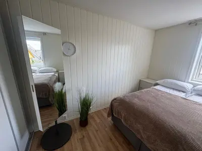 a bedroom with a bed and a clock on the wall at Alesund center room with double bed in Ålesund