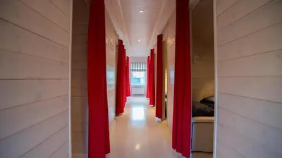 a hallway with red curtains in a room at Posthuset Expedition Lodge in Lii