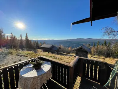 a deck with a table and a view of the mountains at Thorpeset cabin by Norgesbooking - cabin with amazing view in Uvdal