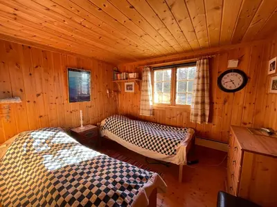 a room with two beds and a clock on the wall at Thorpeset cabin by Norgesbooking - cabin with amazing view in Uvdal