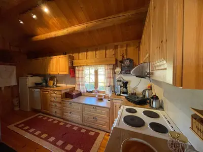a kitchen with wooden cabinets and a stove top oven at Thorpeset cabin by Norgesbooking - cabin with amazing view in Uvdal