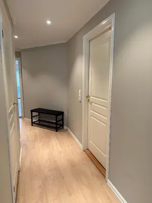 an empty hallway with a door and a table at Modern Apartment in City Center with Parking Garage in Ålesund