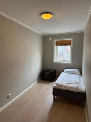 a small bedroom with a bed and a window at Modern Apartment in City Center with Parking Garage in Ålesund