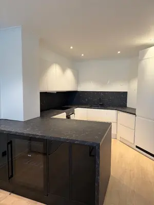 a kitchen with a black island in the middle at Modern Apartment in City Center with Parking Garage in Ålesund