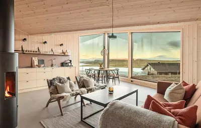 a living room with a table and a large window at 4 Bedroom Awesome Home In Vøringsfoss in Maurset