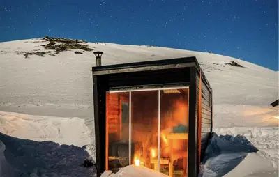 a small cabin in the snow at night at 4 Bedroom Awesome Home In Vøringsfoss in Maurset