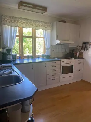 a kitchen with white cabinets and a blue counter top at Cozy house closw in Lii