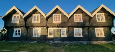 an old wooden house with white windows and a door at Lauvåsen - Langleiken in Sør-Fron
