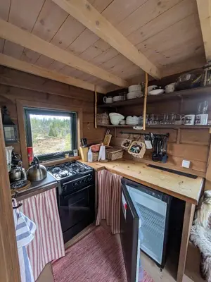 a kitchen with a stove and a counter top at Tretopphytta Kraggbua