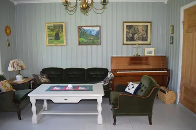 a living room with a table and a piano at Large house by nature reserve