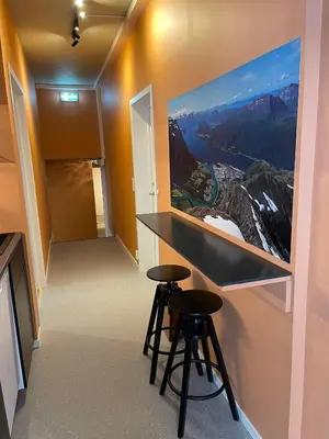 a room with two stools and a painting on the wall at Bakkebo in Åndalsnes