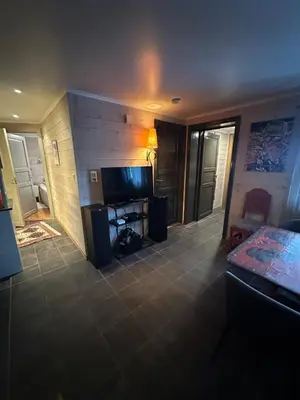 a living room with a flat screen tv and a desk at Ski in-ski out leilighet Hemsedal in Fausko