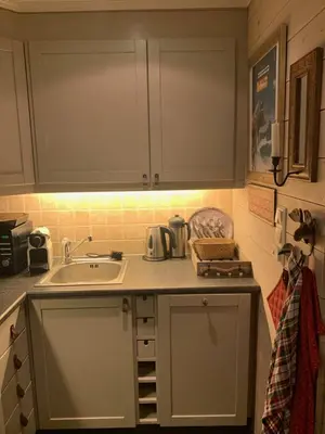 a kitchen with white cabinets and a sink at Ski in-ski out leilighet Hemsedal in Fausko