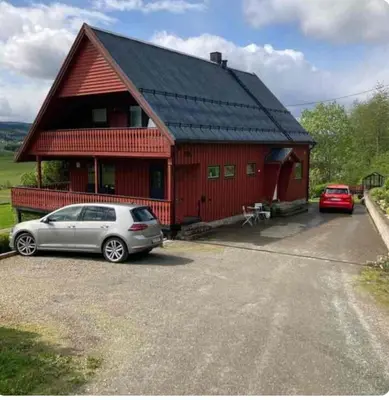a red house with a car parked in front of it at Lilletun in Selbu