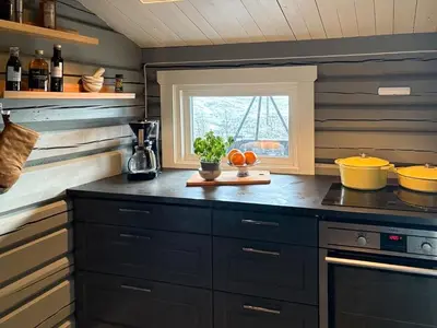 a kitchen with black cabinets and a window at Modernized Log Cabin With Views Of The Mountains in Ron