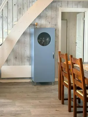 a room with a blue refrigerator next to a staircase at Modernized Log Cabin With Views Of The Mountains in Ron