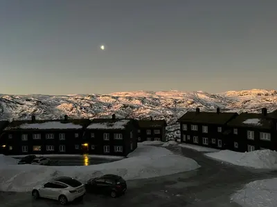 a group of buildings with snow covered mountains in the background at Family-Friendly Mountain Cabin In Haukeli in Nesland
