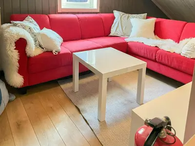 a living room with a red couch and a white table at Family-Friendly Mountain Cabin In Haukeli in Nesland