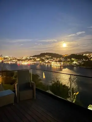 a balcony with a view of a river at night at Daniels House in Kristiansund